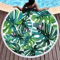 Round tropical monstera leaf beach towel with white tassels on a poolside wooden deck - Green Monstera Style (11)