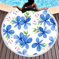 Round beach towel with blue floral print and white tassels on a wooden poolside deck - White with Blue Flowers