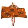 Halloween beach towel with orange base and brown skull pattern held by a model - Orange Skull Stars (10)