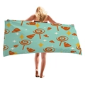 Blue microfiber beach towel with orange lollipop pattern held by a model - Light Blue Candy Stars (11)