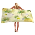 Tropical palm leaf printed beach towel in microfiber material held open by a model - 150x75cm / Multicolor Full Palm Print (9)