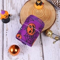 Close-up of purple Halloween ribbon with orange pumpkins and black spider web patterns - Pumpkin Ribbon