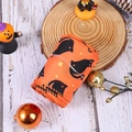 Close-up of orange Halloween ribbon with black cat and star prints on a rustic wood base - Black Cat Ribbon