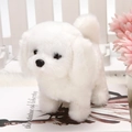 White plush electric toy puppy with fluffy fur standing on books in a cozy setting - White
