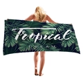 Tropical green palm leaf beach towel with white Tropical Dream text shown held by model - Tropical Dream Letter Style (8)
