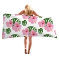 Tropical beach towel with pink hibiscus and monstera leaves held by a model - Pink Hibiscus And Monstera (1)