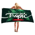Deep green tropical leaf print beach towel with Tropic Leaves text held by a model - Tropical Leaves Red Label Style (6)