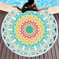 Round mandala beach towel with white tassels and vibrant geometric patterns on wood deck - Blue Green Turmeric Mandala (4)