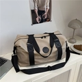 Grande borsa da viaggio kaki con cinghie nere in un ambiente domestico minimalista - Cachi