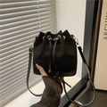 Fashionable black drawstring bucket bag in soft suede with elegant gold hardware - Black
