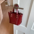 Retro wine red patent leather tote bag with gold hardware shown on a white door - Red