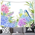 Floral wall tapestry with watercolor blue hydrangeas and bird hanging over a gray sofa - Hydrangea and Bird