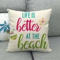 Federa per cuscino quadrata color crema con stampa spiaggia tropicale su un divano grigio - Bevanda al Cocco (Life is better at the beach)