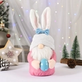 Gnome de Pâques avec oreilles roses et barbe blanche tenant un œuf à pois bleus - Style Oreilles de Lapin Roses