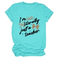 Close-up of turquoise cotton T-shirt featuring 'I'm literally just a teacher' text and bows - S / Tops / Deep Water Blue