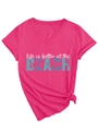 Detail of hot pink V-neck T-shirt with Life is better at the BEACH print and hem knot - S / Rose Red