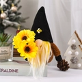 Sunflower gnome with black pointed hat and bee decor sitting on book with pinecones - Black Hat Style