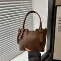 Coffee brown pebbled leather bucket bag with wave-cut top and golden hardware - Brown
