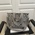 Grey corduroy tote bag with black bow print and adjustable strap on a vintage chair - Gray
