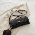 Schwarze Baguette-Tasche mit Kroko-Prägung und stilvoller goldener Knotenschließe - Schwarz
