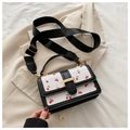Detail of white square crossbody bag featuring red cherry print and wide black strap - Black