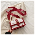 Detailed view of cherry print square handbag with red trim and wide fabric strap - Red