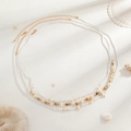 Detalle de cadenas bohemias para la cintura con dijes de estrella de mar y perlas en arena - Estilo Colgante Concha Estrella de Mar Oro Blanco (06278)