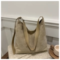 Minimalistische beige Wildleder-Einkaufstasche mit Lederriemen auf Strickdecke - Khaki
