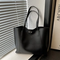 Minimalistische zwarte leren tote bag met gesp detail in zacht vensterlicht - Zwart