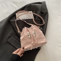 Pale pink drawstring bucket bag with silver metal bow and textured leather finish - Light Pink