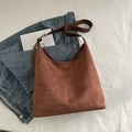 Braune Shopper-Tasche aus Wildlederimitat mit Lederriemen auf weißem strukturiertem Stoff - Braun