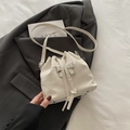 Chic cream white drawstring bucket bag with silver bow detail and pleated leather texture - White