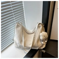 Détail d'un sac cabas ivoire avec breloque nuage posé sur un rebord de fenêtre ensoleillé - Blanc Avec Pendentif