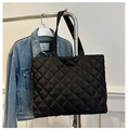 Detail of black quilted puffer tote bag in glossy nylon fabric with wide handle strap - Black
