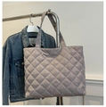 Close-up of quilted tote bag in mauve with glossy texture hanging on a metal rack - Gray