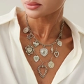 Detailed close-up of a silver multi-charm necklace featuring hearts and sun pendants - Necklace-Silver (7317)