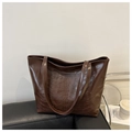 Dettaglio del rilievo a scheletro sulla borsa tote in pelle PU marrone scuro lucida - Marrone