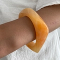 Dettaglio del bracciale in resina ambrata con bordi ondulati e trama sabbia marmorizzata - Arancione Ambra-02252