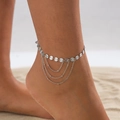Close-up of a silver sequin anklet with layered fringe chains on a sandy beach setting - Sequin Tassel Style (00910) / Silver