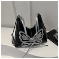 Detalle del bolso negro con un gran aplique de mariposa plateada y un lazo - Negro