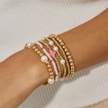 Gros plan de bracelets bohèmes à plusieurs rangs avec perles et pendentif croix au poignet - Ensemble 6 Pièces Or (6462)