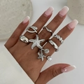 Eight-piece silver ocean theme ring set featuring starfish, shells, and pearls on a hand - Silver Ocean Theme Decor Style
