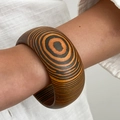 Breiter geometrischer Holzarmreif mit markantem orange-schwarzem Jahresring-Muster - Schwarz Oranges Konzentrisches Ring-Holzmaserungs-Stil (0115)