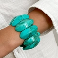 Detailopname van een turquoise harsarmband met marmertextuur aan een vrouwenpols - Lichtgroen Marmeren Hars Stijl (0119)