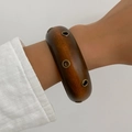 Wide vintage wooden cuff bracelet with bronze metal eyelets on a female model - Dark Brown (0110)