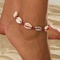 Bracelet de cheville coquillage bohème avec cordon rouge sur une plage de sable - Chevillère en Corde Rouge Tissée Coquillage (0432)
