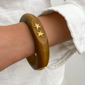Detail eines breiten Vintage-Resin-Armreifens mit goldenen Sternen am Handgelenk - Hellbrauner Stern Dekor Stil(0109)