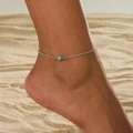 Bracelet de cheville bohème en argent avec perle turquoise porté sur une plage ensoleillée - Chevillère en Perles de Turquoise Argentée (0078)