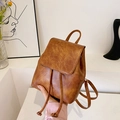 Vintage brown mini backpack with drawstring closure and flap cover in a minimalist setting - Brown
