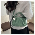 Detail of green suede handbag with heart charm and striped scarf in a casual setting - Green Without Pendant